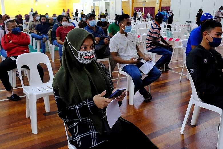 People waiting in an observation area after receiving their jabs at a vaccination centre at the PKNS Sports Complex in Kelana Jaya, Selangor, last Wednesday.