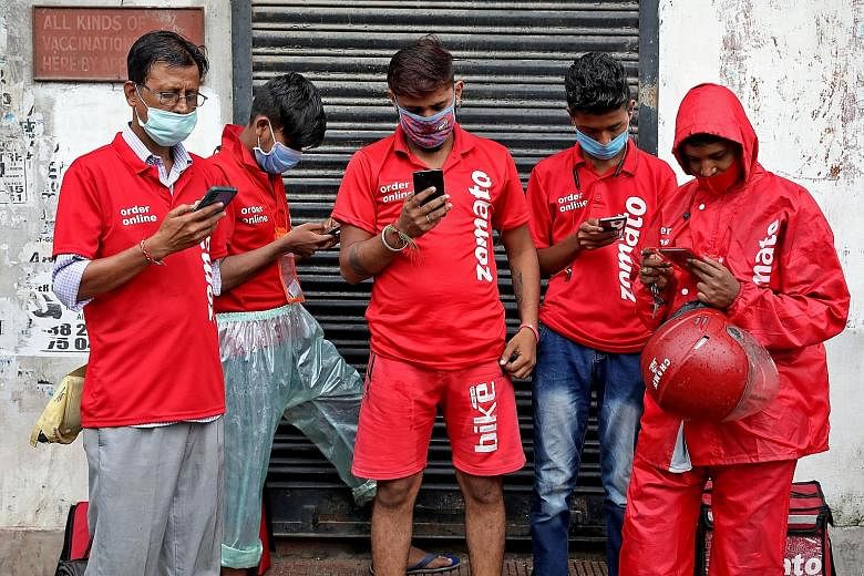 Delivery workers from Indian food delivery service Zomato waiting to collect orders outside a restaurant in Kolkata last month. Some of the company's riders have complained of long working hours that come with risks such as accidents, police harassme