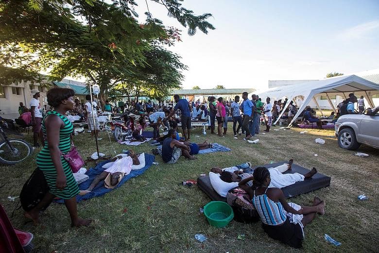 Patients and their relatives outside a hospital in Les Cayes, Haiti, damaged by last Saturday's earthquake. In Les Cayes, as in other hard-hit cities on the south-western peninsula, most of the population spent the night sleeping outdoors in front of