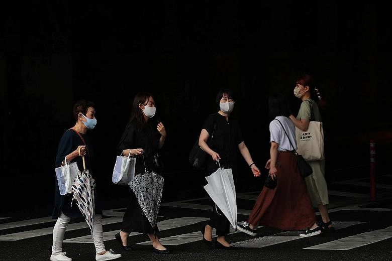 Women in Fukuoka wearing face masks yesterday, amid the Covid-19 outbreak. Japan recorded 19,955 cases yesterday as the number of patients in intensive care or on life support rose to another new peak of 1,646. PHOTO: REUTERS