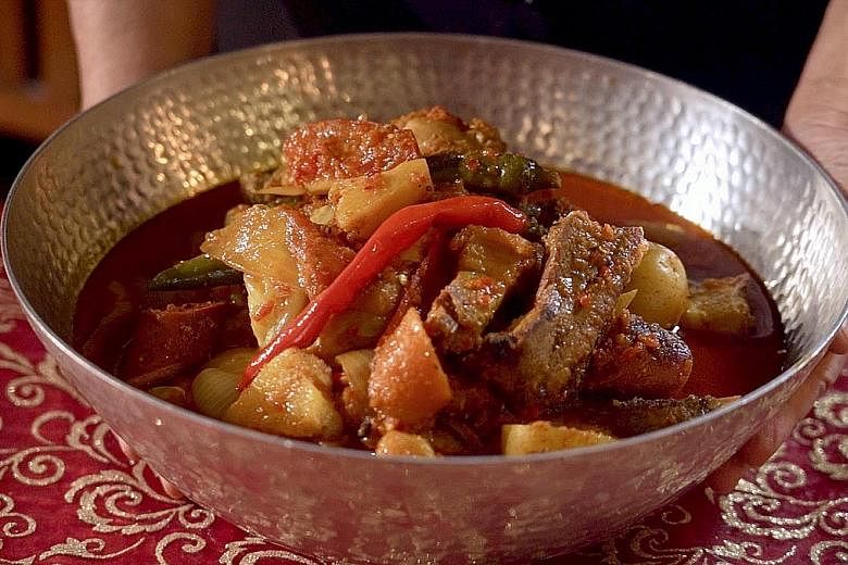 Straits Times Senior Food Correspondent Wong Ah Yoke and home-grown chef Violet Oon cook a dish of Curry Devil. The luxurious combination of ingredients like chicken, pork ribs, sausages, Chinese roast pork and lapcheong in this dish spells taste and