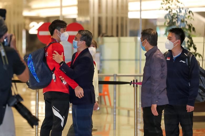 Minister for Culture, Community and Youth Edwin Tong welcomes Loh Kean Yew at Changi Airport Terminal 1.ST PHOTO: GAVIN FOO