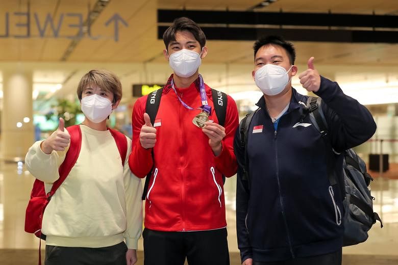 Loh Kean Yew with national singles coach Kelvin Ho and physiotherapist Ho Jia Ying at Changi Airport Terminal 1.