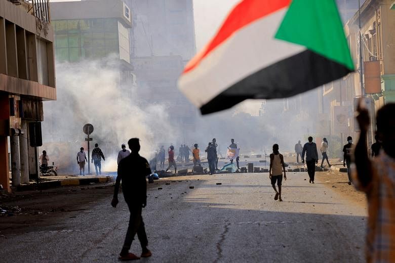 <p>FILE PHOTO: People march to the presidential palace, protesting against military rule following last month's coup in Khartoum, Sudan December 19, 2021. REUTERS/Mohamed Nureldin Abdallah/File Photo</p>