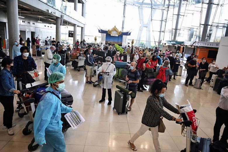 <p>International visitors await instructions from health officials inside the arrival terminal at Suvarnabhumi International Airport as Thailand welcomes the first group of vaccinated tourists without quarantine in Bangkok on November 1, 2021. (Photo by L