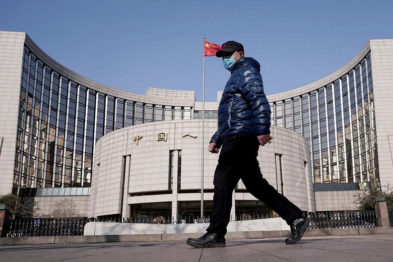 <p>FILE PHOTO: A man wearing a mask walks past the headquarters of the People's Bank of China, the central bank, in Beijing, China, February 3, 2020. REUTERS/Jason Lee/File Photo</p>