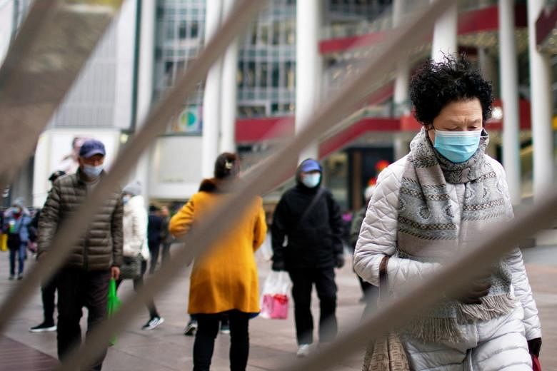 <p>People wearing face masks following the coronavirus disease (COVID-19) outbreak walk on a shopping street in Shanghai, China, December 14, 2021. REUTERS/Aly Song</p>