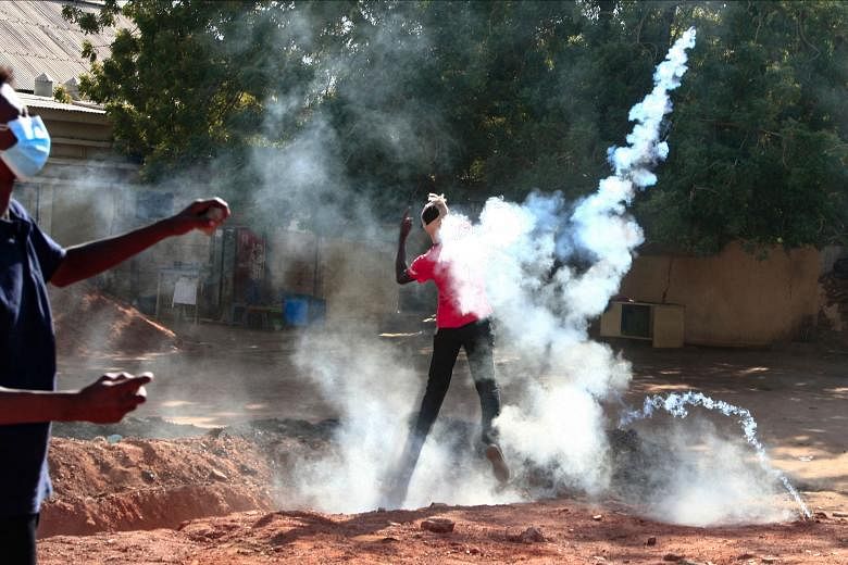 A Sudanese protester returning tear gas canisters fired by security forces, in Khartoum, Sudan, on Dec 25, 2021.