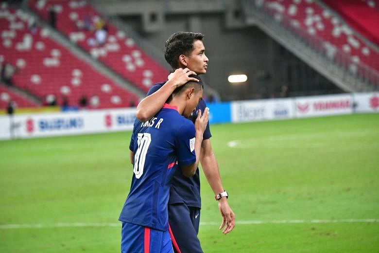 Faris Ramli was consoled by Singapore Defender #21 Safuwan Baharudin Indonesia won 4-2 after extra time during the Second leg of AFF Suzuki Cup semi-finals between Singapore and Indonesia.