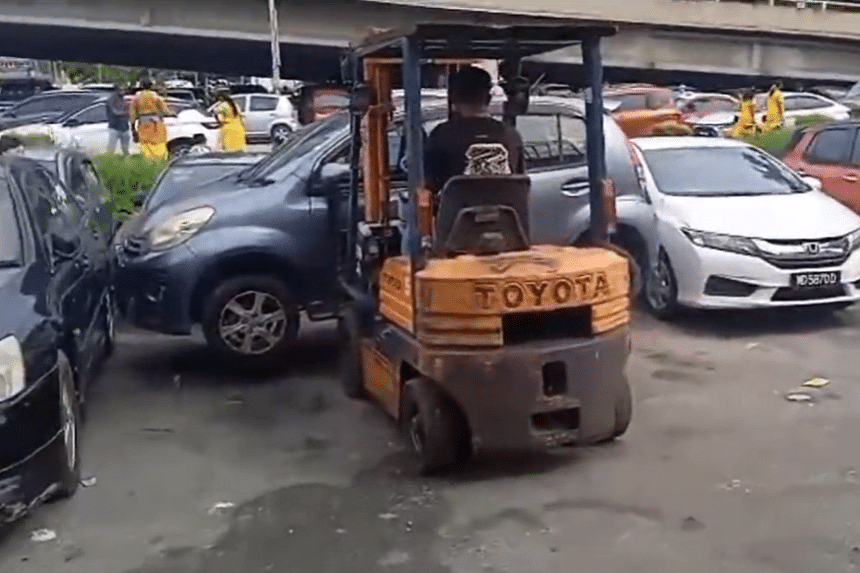 Malaysian man uses forklift to remove parked cars blocking his