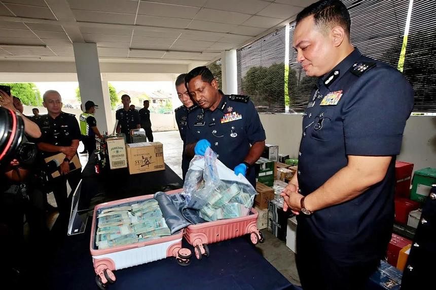 马来西亚警方记录一名男子在商场停车场扔下装有 142,000 美元包裹的声明
