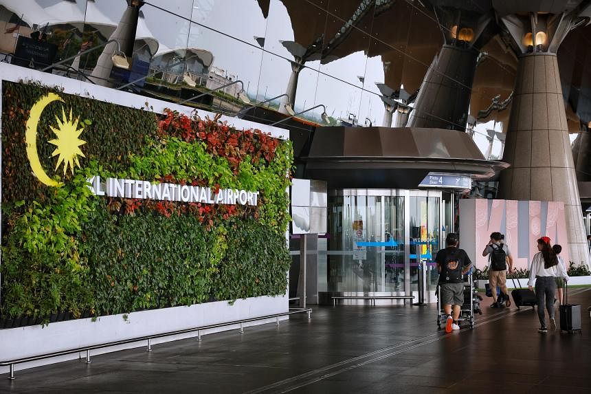 冒充移民官员在马来西亚吉隆坡国际机场向外国人勒索钱财的兜售者