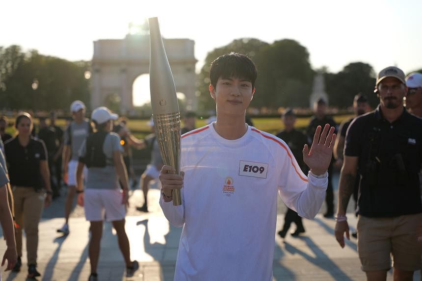 BTS singer Jin takes part in the torch relay at the Paris Olympic Games