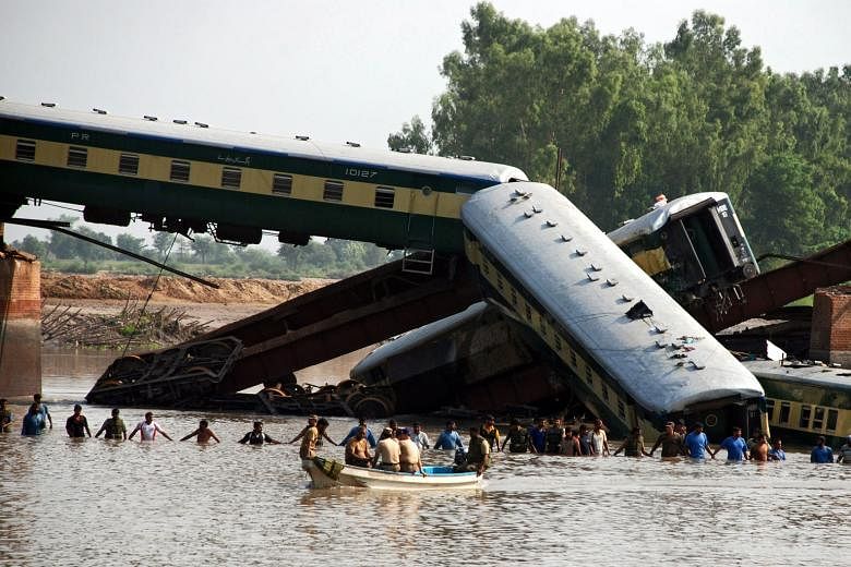 Soldiers searching for survivors and the bodies of victims yesterday. The train fell into a canal after a bridge collapsed. Railways Minister Khawaja Saad Rafique has denied that the bridge was run-down.