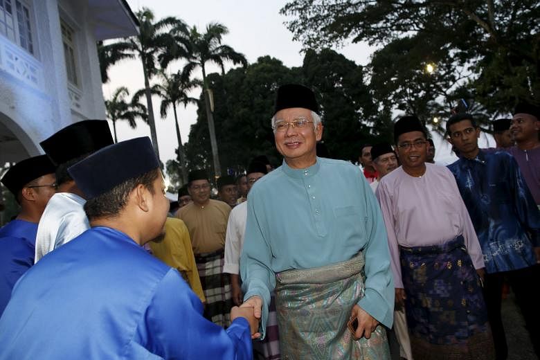 Mr Najib Razak (centre) arriving at a break fast event in Johor yesterday. The opposition has called on him to step aside to allow an independent probe into media allegations of corruption.