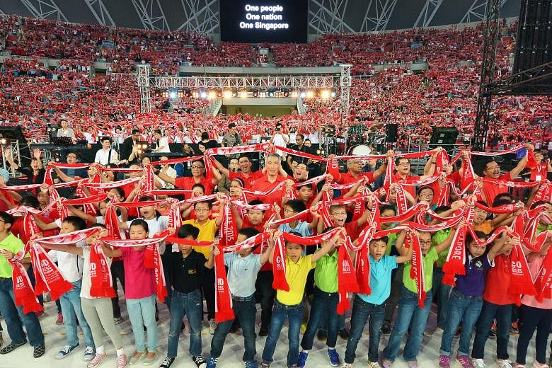 PM Lee Hsien Loong joining children on stage to sing One People, One Nation, One Singapore with the crowd during the Jubilee Day of Prayer at the Sports Hub yesterday. The event was co-organised by the National Council of Churches in Singapore and th