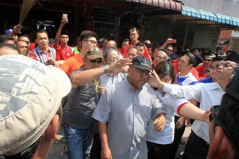 Mr Syed Othman Syed Abdullah from the Democratic Action Party being slapped as he and other opposition party members, including veteran leader Lim Kit Siang, make their way out of the coffeeshop in Johor where they were holding a forum on Sunday.