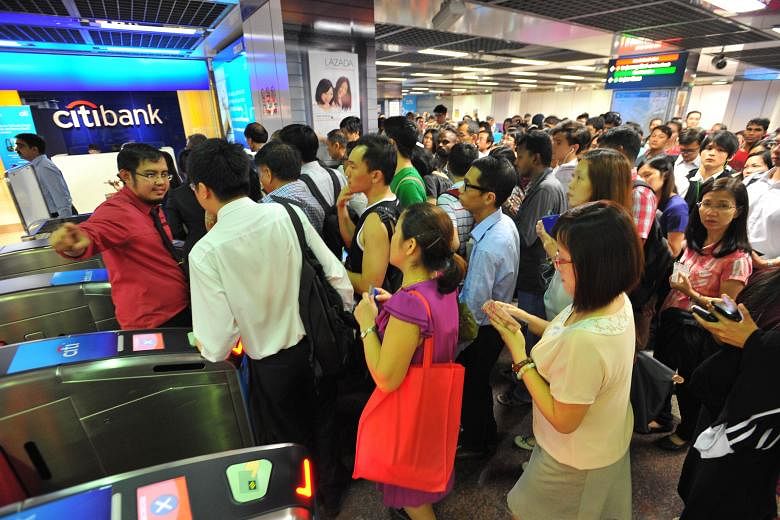 Crowds at City Hall MRT station being directed away from the fare gates leading to the trains. A power trip, which could have been caused by a faulty train, crippled services throughout the North-South and East-West lines for more than two hours from