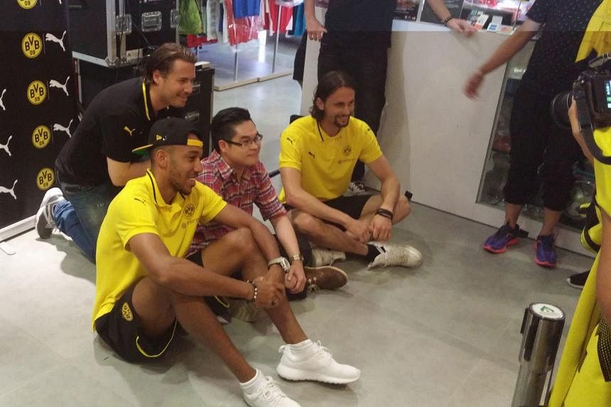 Above: Time to meet the king of fruits at Nanyang Polytechnic, as Dortmund's (from left) Gonzalo Castro, Roman Burki and club legend Karl-Heinz Riedle have their first feel of durian blindfolded. Right: Over at 313@Somerset, Dortmund players (from le