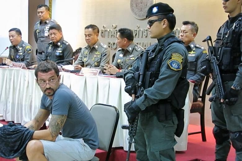 Swiss national Xavier Andre Justo (in T-shirt), a former PetroSaudi employee, being presented at a press conference at the Royal Thai Police head office, following his arrest for blackmail.