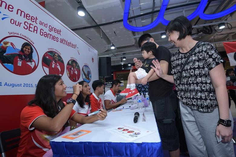 Team Singapore athletes (from left) Sasha Christian, Shanti Pereira, Bernie Chin and Eugene Teo signed autographs for supporters at the NTUC FairPrice supermarket at Kallang Wave mall yesterday. The event was to celebrate the athletes' superb perform