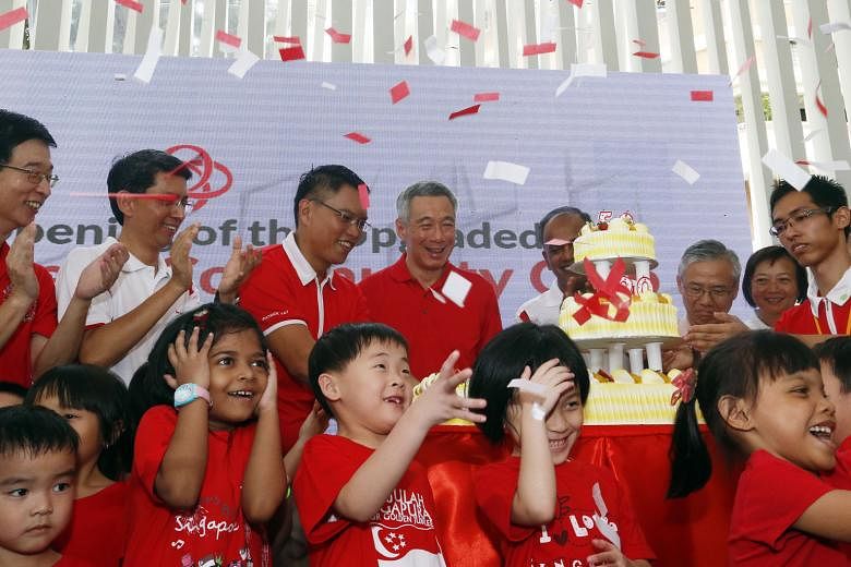 Children cheering as PM Lee celebrated the reopening of the Nee Soon East Community Club with MPs from the constituency, including Mr Patrick Tay (on PM Lee's right) and Mr K. Shanmugam (right).