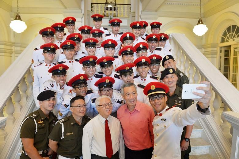 President Tony Tan Keng Yam and Prime Minister Lee Hsien Loong joining in a group photograph with the ceremonial guard of the Singapore Armed Forces Military Police Command at the Istana yesterday. They were attending an early National Day observance