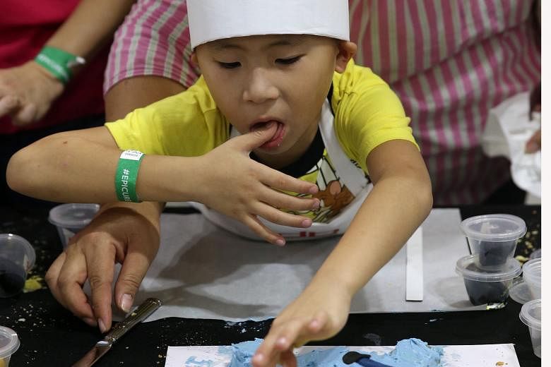 It's finger licking good as Brendon Au, seven, puts the finishing touches to his Minion cake. He was one of 33 children who took part yesterday in the junior pastry chef masterclass, conducted by executive pastry chef Benjamin Siwek of db bistro & Oy