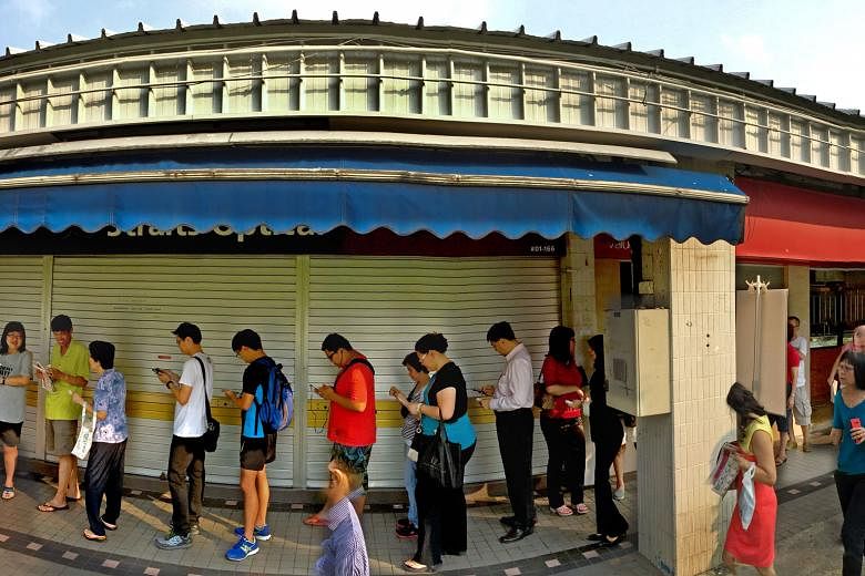 People waiting in line at POSB's Tampines Central branch yesterday to exchange currency notes for the new commemorative SG50 ones. The queue at some places like DBS Bank in Junction 8 was up to six hours long.
