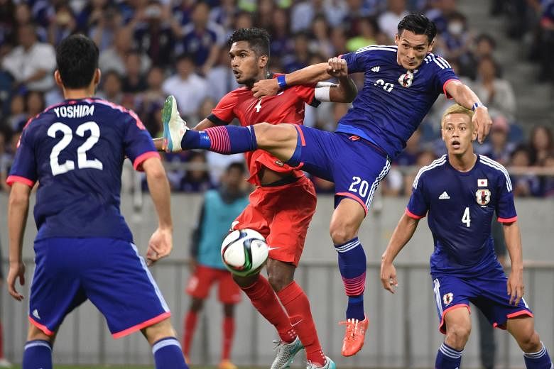 Hariss Harun (left) tussling with Japan's Tomoaki Makino during the 0-0 World Cup qualifier draw in Saitama in June. The Singapore vice-captain expects his side to keep up their good form against Syria.