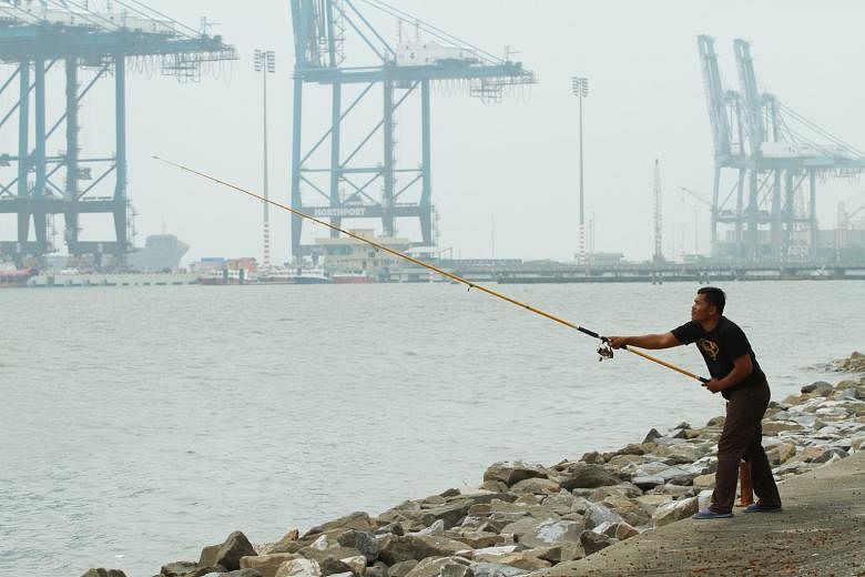 A man persevering with his fishing despite the poor visibility near North Port, in Port Klang, on Tuesday afternoon.