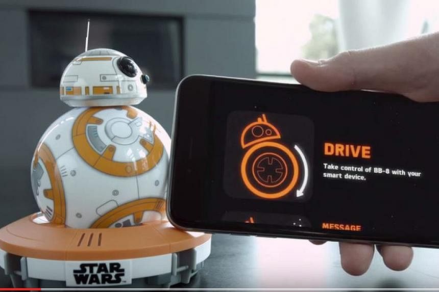 Fans dressed as Star Wars characters pick new toys from the upcoming film in Hong Kong (left) while BB-8 (above) is set to be the movie's most beloved robot following the toy's launch yesterday. With a smartphone as a controller, users can steer it a