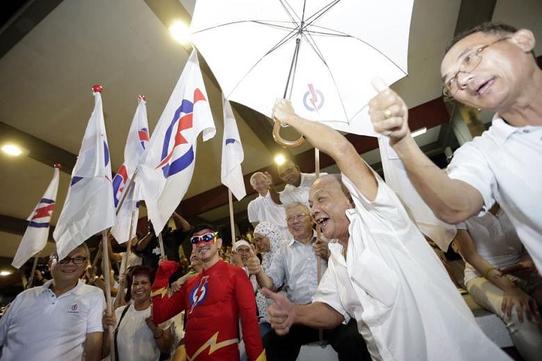 PAP supporters in high spirits at Toa Payoh Stadium, where they awaited the results of the polls last night.