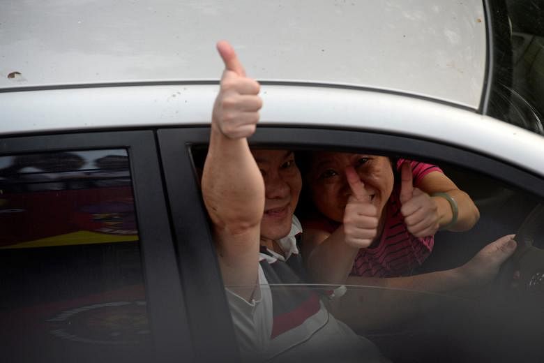 Tanjong Pagar residents waving to the PAP team yesterday as they rode through the estate on a lorry thanking residents for their support. Mr Charles Chong, who won in Punggol East SMC, as well as the PAP teams from Tampines, Pasir Ris- Punggol and Ja