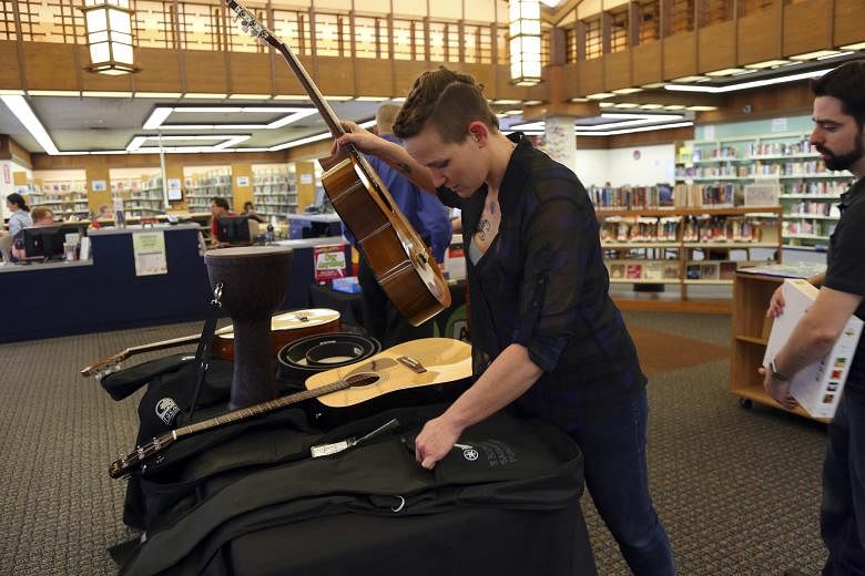 The library also carries guitars (far left) and a 3-D printer, which people have used to create different things (left). Sacramento Public Library's Rivkah K. Sass (above left) and Lori Easterwood with games, puppets and other items.