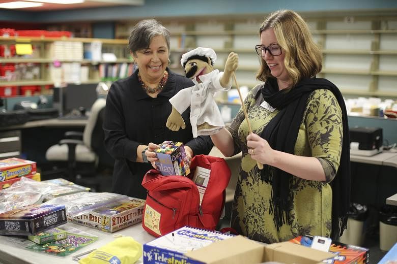 The library also carries guitars (far left) and a 3-D printer, which people have used to create different things (left). Sacramento Public Library's Rivkah K. Sass (above left) and Lori Easterwood with games, puppets and other items.