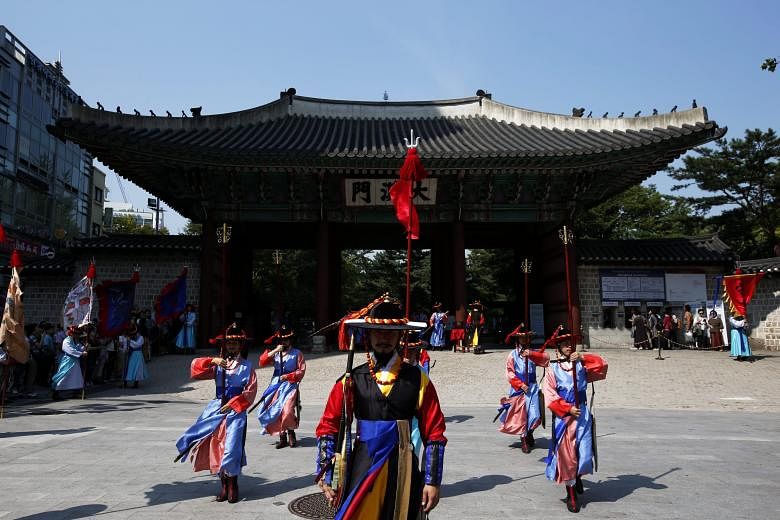 South Korean officials in Royal Guard uniforms performing the changing of the guard ceremony at Deoksugung Palace in Seoul, South Korea, yesterday. The ceremony is a popular spectacle for tourists in the capital city.