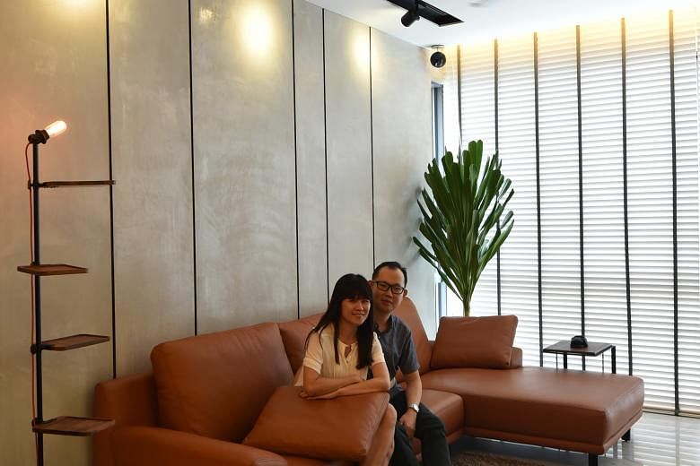 Mr Dave Siah and Ms Wendy Koh (both above) shopped overseas for accessories for their home, such as a $800 standing light (above left) from Bangkok. A six-seater wood table (left), the centrepiece in the dining room, lets the family of four lounge ar