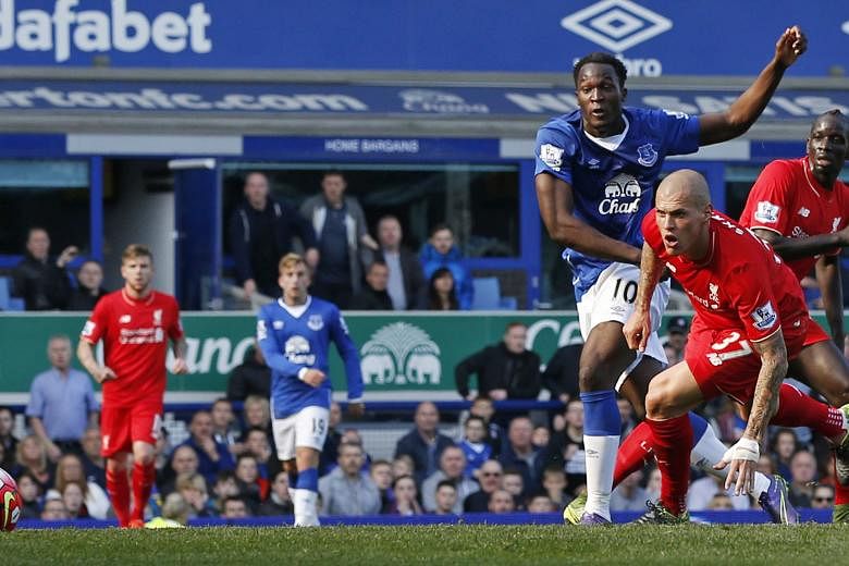 Above: Romelu Lukaku scoring the equaliser for Everton. The Belgian striker was nevertheless disappointed as he thought it was a great chance to beat Liverpool. Left: As with a Merseyside derby, thing got a bit testy during the match with this flare-