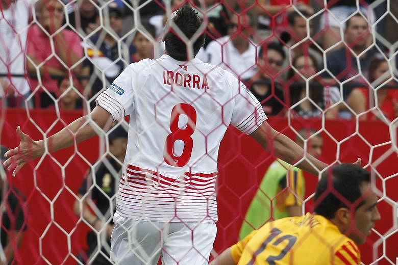 Midfielder Vicente Iborra wheeling away in delight after netting Sevilla's second goal as Barcelona goalkeeper Claudio Bravo looks away in disappointment. Sevilla took advantage of terrible defending by the visitors to win the match 2-1.