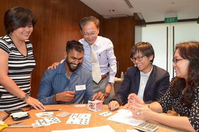 Nanyang Business School lecturer Clive Choo (centre) with participants (from left) Mrs Josephine Low, Mr Prem Roy, Ms Ang Ee Li and Ms Sharon Goh in a prototype-building exercise.