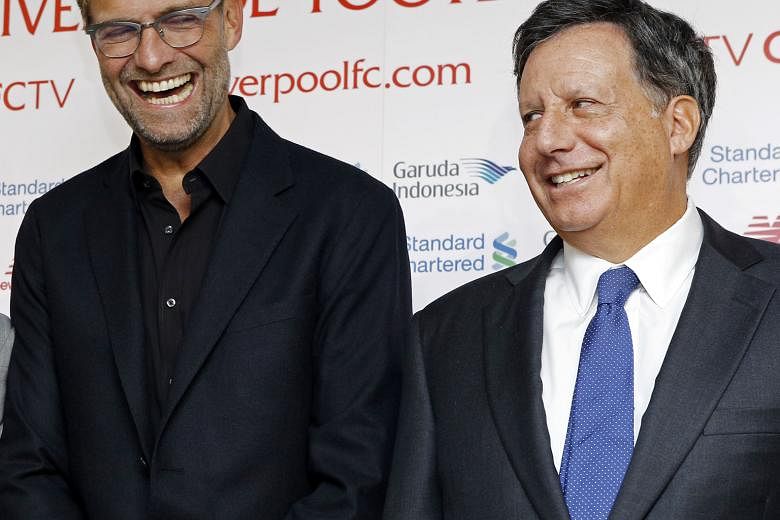 New Liverpool manager Juergen Klopp (left) sharing a laugh with club chairman Tom Werner at a press conference last Friday. The German says that while he is not under pressure to deliver in his first season, he has been tasked with getting the Reds t