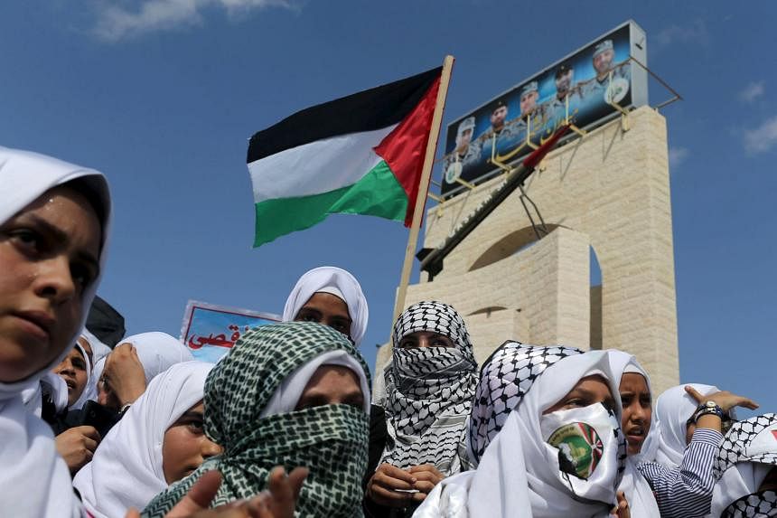 Palestinian students taking part in a rally to show solidarity with Palestinians clashing with Israeli troops in the West Bank and Jerusalem, in the southern Gaza Strip, yesterday. Seven Israelis and 29 Palestinians have been killed in two weeks of b