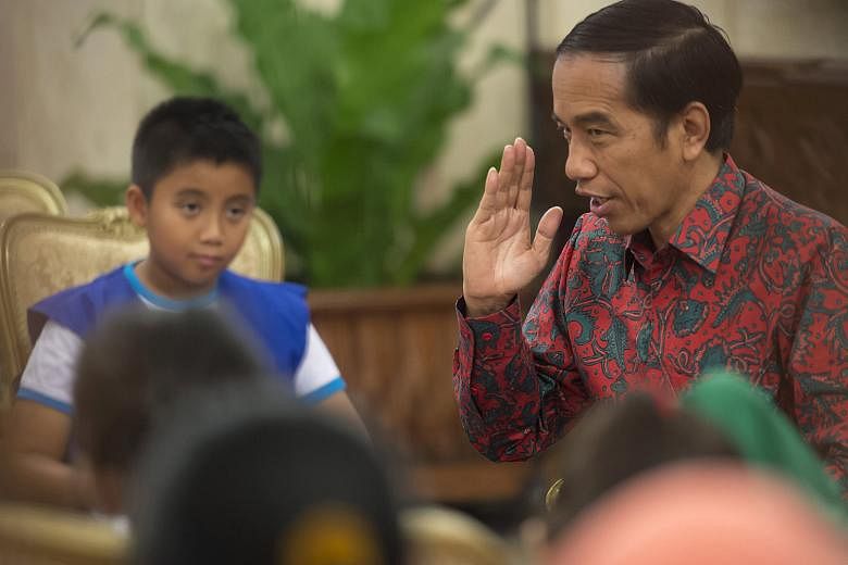 President Joko Widodo answering questions from elementary school pupils playing the role of young reporters at the Presidential Palace in Jakarta yesterday.