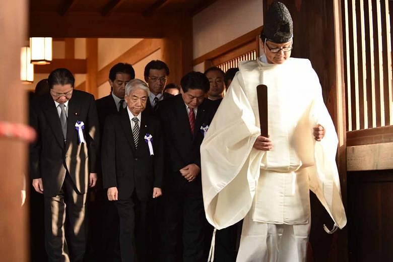Japanese lawmakers following a Shinto priest during a visit to the controversial Yasukuni shrine yesterday.