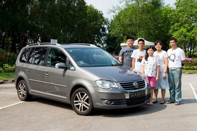 Mr Nicholas Ng (right), wife Liping and their children (from far left) Nicodemus, Nathan and Lydia with their family car.