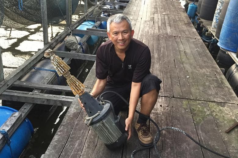 Metropolitan Fishery Group chief executive Malcolm Ong with an aerator that AVA co-funded, at one of his offshore fish farms in Lim Chu Kang.