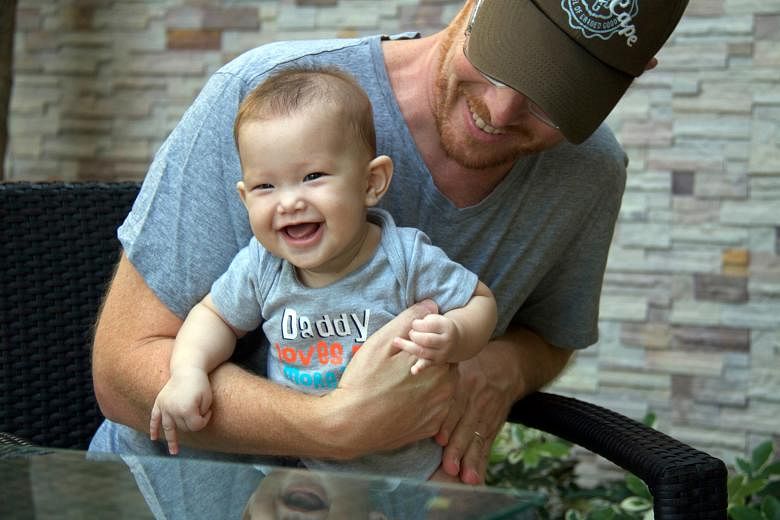 Mr Gordon Lake with baby Carmen who was delivered via Thai surrogate Patidta Kusolsang. Mr Lake and his husband are fighting for parental rights over Carmen, which Ms Patidta refuses to cede.