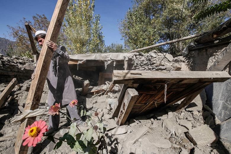 A man removing debris from what is left of his home at Hinjol village in Chitral valley, Pakistan, yesterday. Thousands of survivors sharing his plight are desperate to rebuild their homes quickly before winter sets in. The quake damaged about 14,000