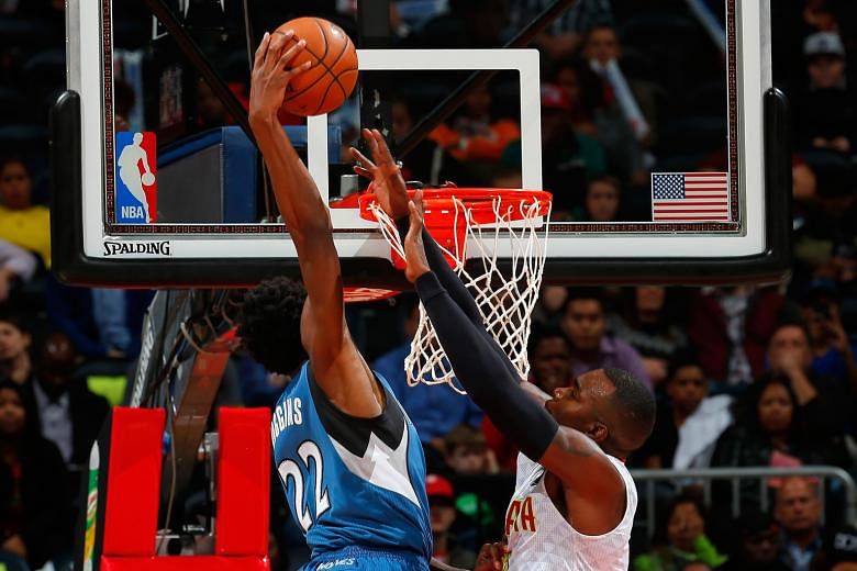 Andrew Wiggins of the Minnesota Timberwolves dunking over Paul Millsap of the Atlanta Hawks at Philips Arena. Guard Wiggins scored 33 points in Minnesota's 117-107 victory, their first in 13 games in Atlanta in nearly 13 years.